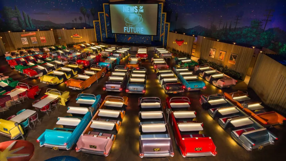 Interior escuro do Sci-Fi Dine-In com mesas em formato de carro